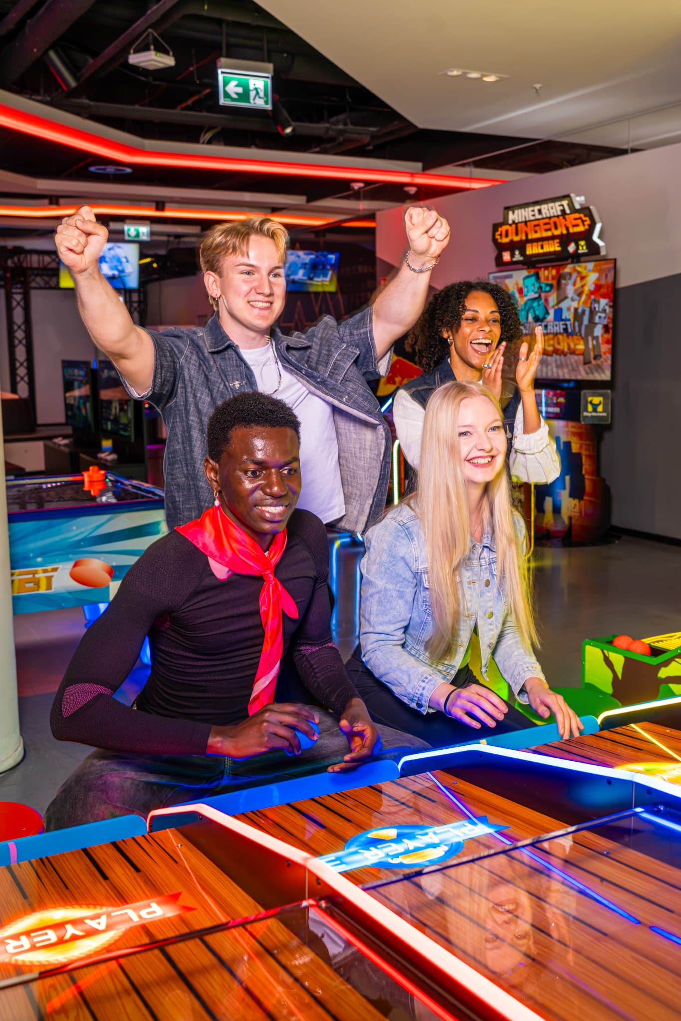 Team celebrating together at an arcade machine