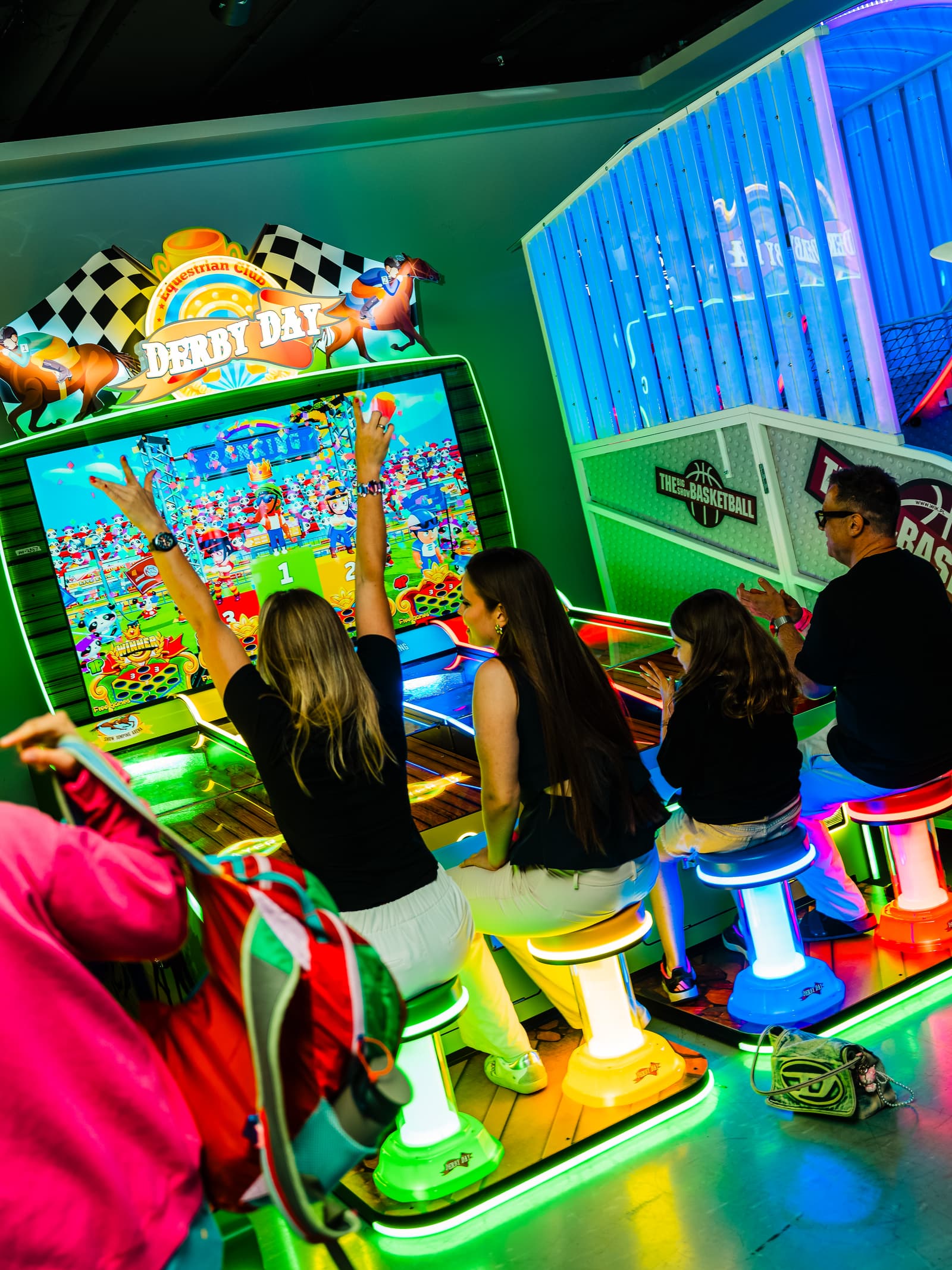 A group celebrating together at the Derby Day arcade racing game